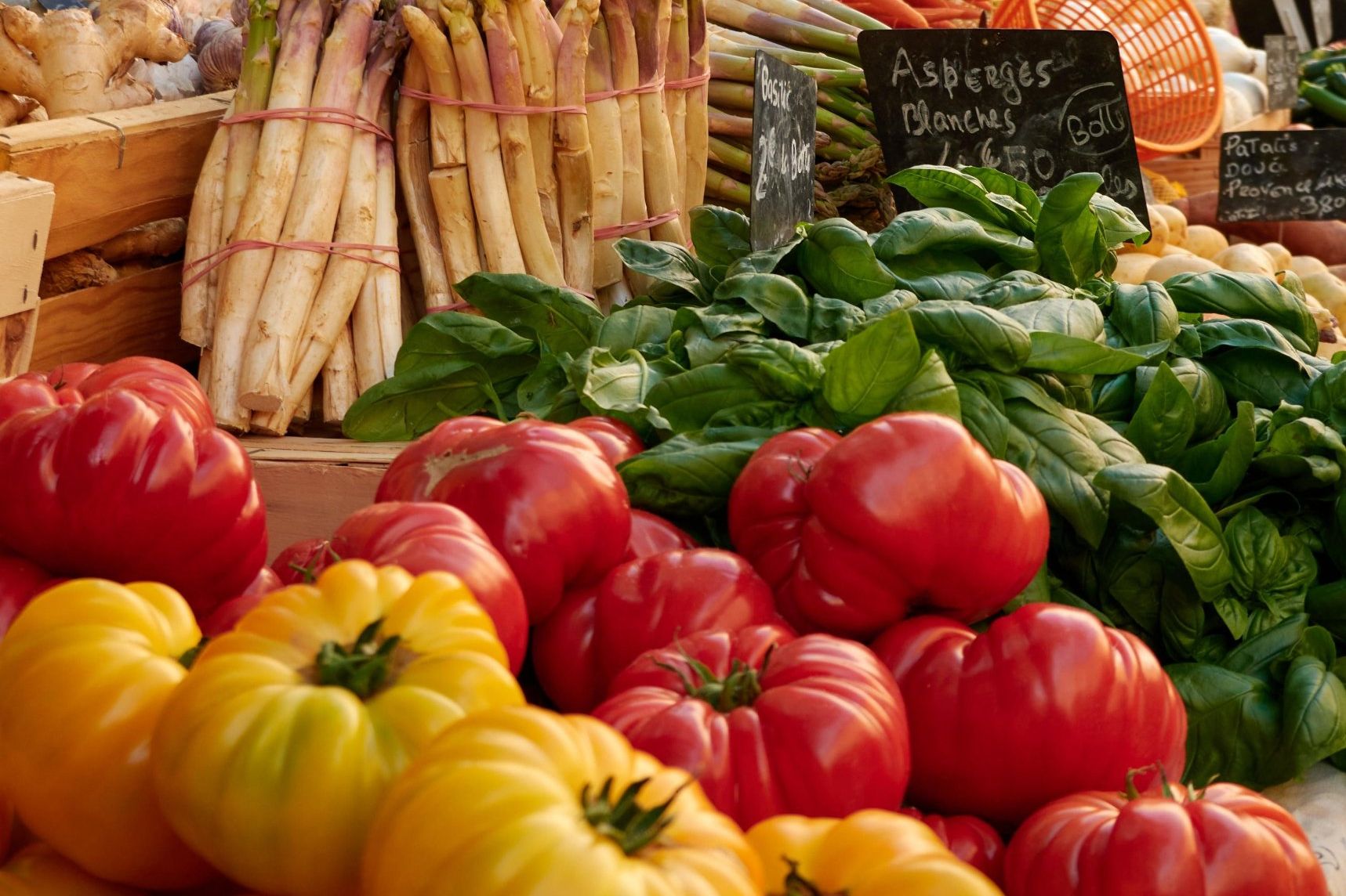 Heirloom tomatoes, basil and asparagus on a Provençal market stall.